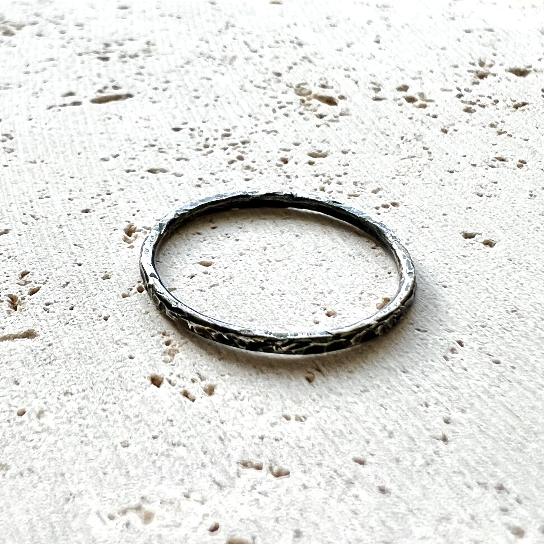 Six Elements Goddess - Earth Silver Stacking Ring handmade textured ring on a travertine surface - 6 elements Studio